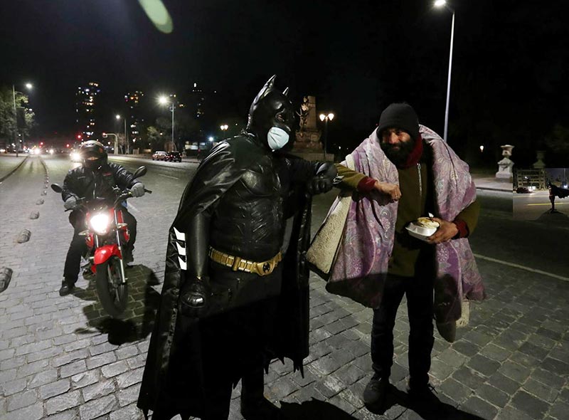 Batman soldario (Solidarity Batman) delivering food to the homeless in Santiago. Chile